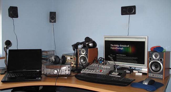 A picture of my desk full of technology. You can see the mixer, laptop, Kenwood Amiture radio, microphones, keyboards and a lot of speakers. Click to see full size.