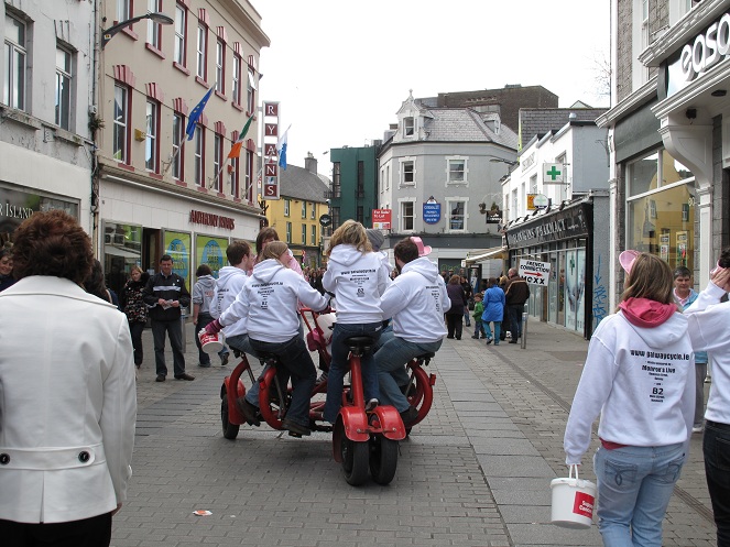 Wow this is hard to explain. Basically it's a huge bike. Everyone sits in a circle facing each other.  There are about five people on it I think. They all peddle but only one person stears.